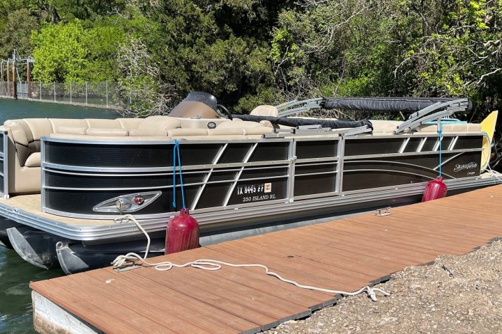 a boat sitting on top of a wooden dock over some water